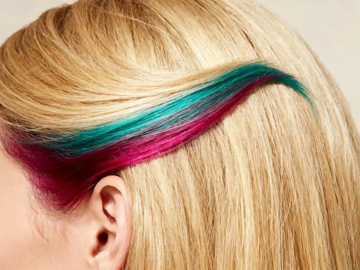 Blond włosy z turkusowo-magenta pasmami ukrytymi pod spodem